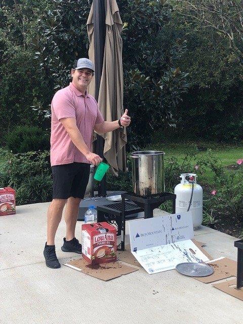 man posing next to frying a turkey